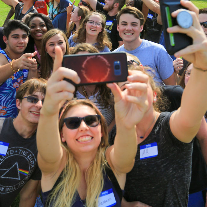 Newly admitted U A H students take a smiling selfie.