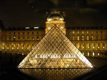Glass pyramid in front of the Louvre at night.