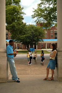 Students talking under column entrance-way.
