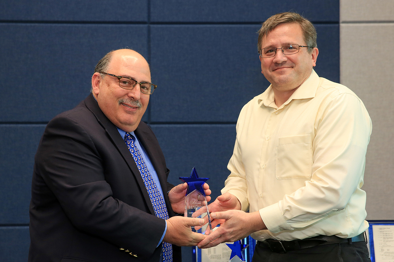 Dr. David Berkowitz, dean of UAH’s Graduate School, presents the 2018 graduate mentoring award to Dr. Larry Carey, chair of the Atmospheric Science Department, during the university’s annual awards day ceremony. (UAH Photo/Michael Mercier)
