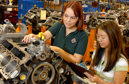 Two students working on an engine