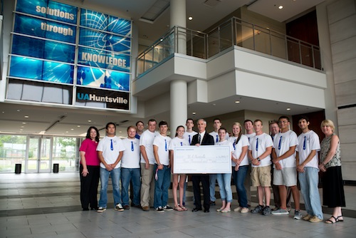 Vice President and Corporate Lead Executive for Northrop Grumman in Huntsville, Retired Lt. General Kevin Campbell provides a $4,000 check to UAHuntsville for the university's engineering education efforts. Posing with Campell are UAHuntsville engineering students and local high school students interested in the engineering field.