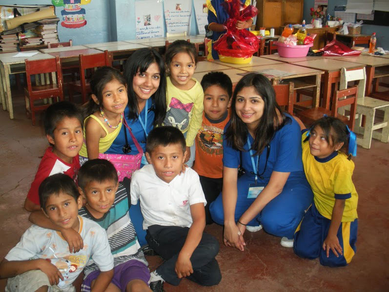 picture of children in a classroom standing beside teachers