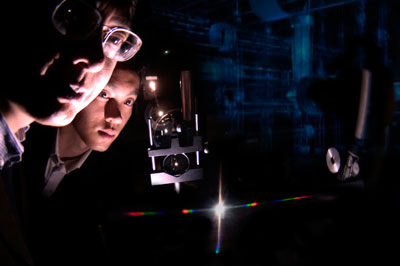 Dr. Junpeng Guo, UAHuntsville Associate Professor of Electrical Engineering and Optics, and doctoral student Haisheng Leong view the spectra from a new nanoscale photonic device called a super nano-grating.