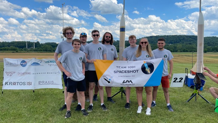 group photo of Team Spaceshot members outside holding their banner