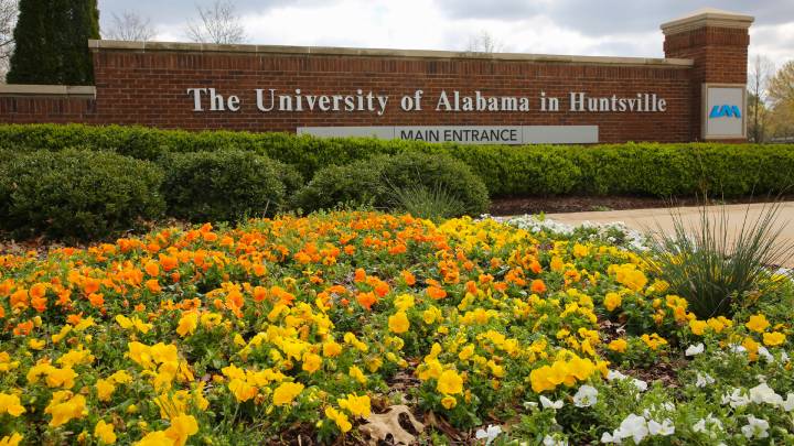 main entrance of uah with brick walls and flowers in bloom
