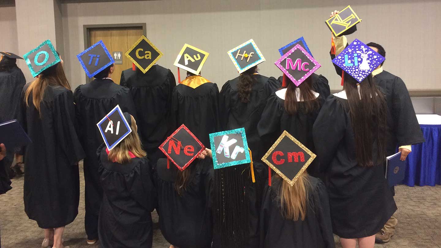 Graduation students standing wearing graduate robes