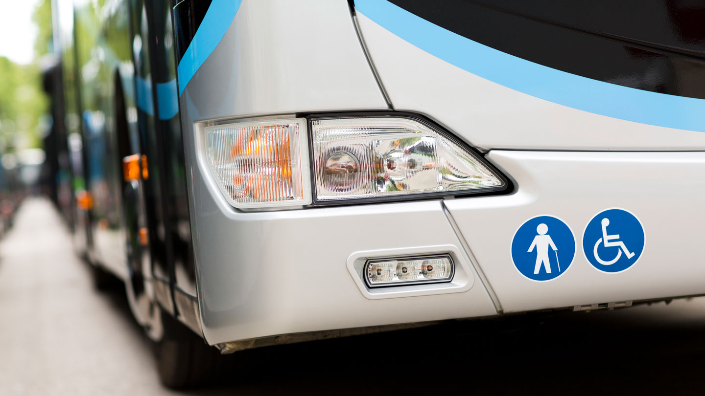 a modern city bus with elderly and wheelchair icons on the bumper