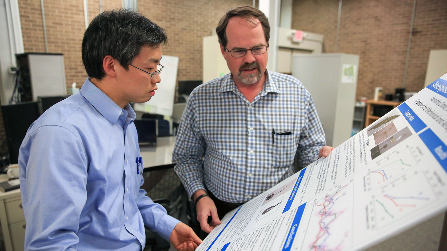 A UAH engineering management student discusses a project board with a faculty mentor.