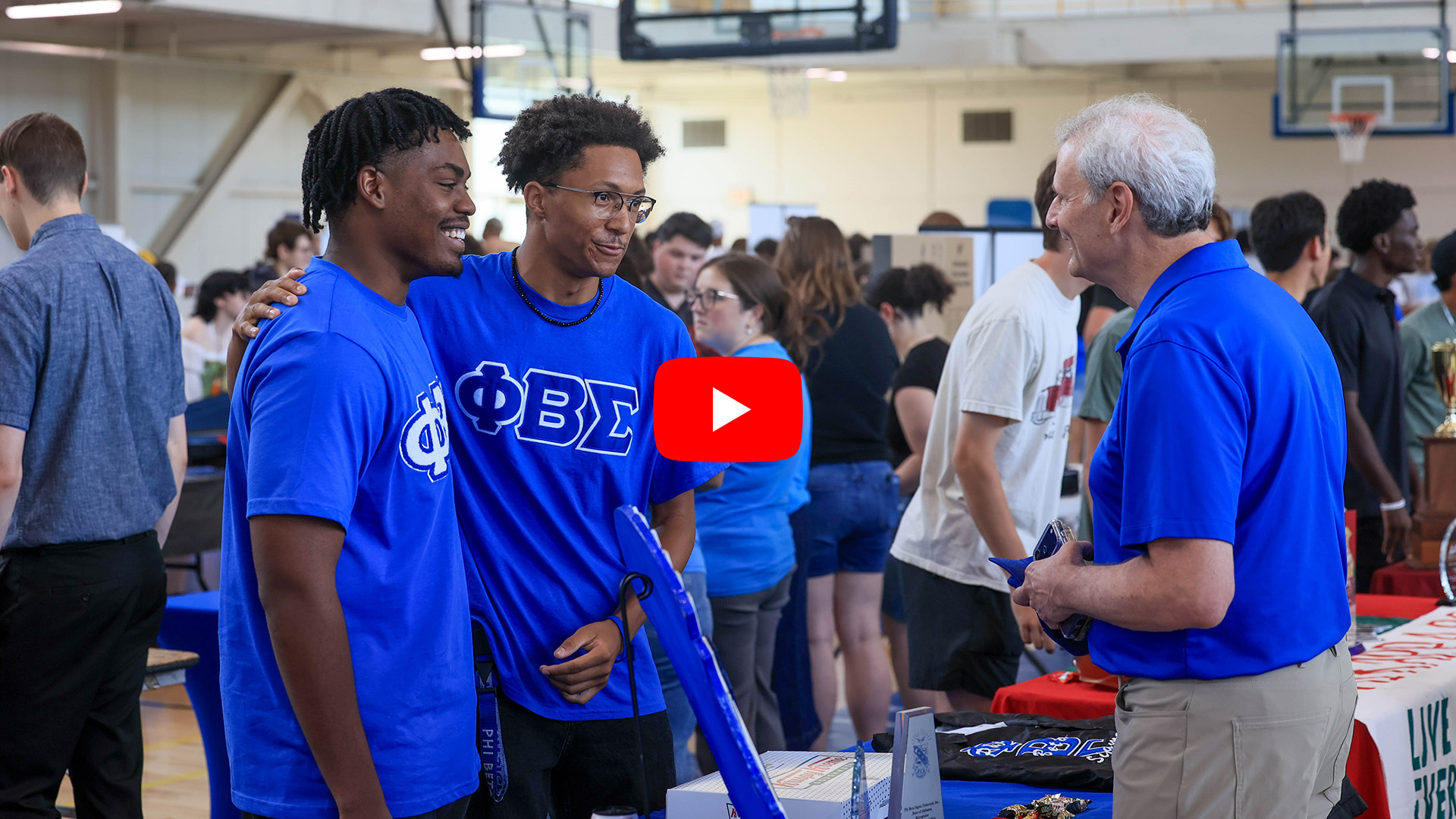 Dr. Don Leo speaks to two students at the Student Organization fair, Video Play Button