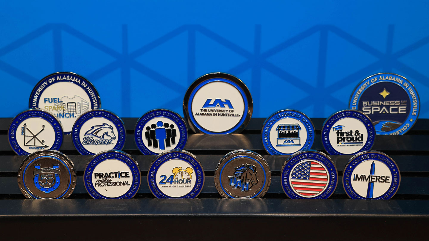 A collection of U A H Challenge Coins given to encourage student achievement in a variety of subjects