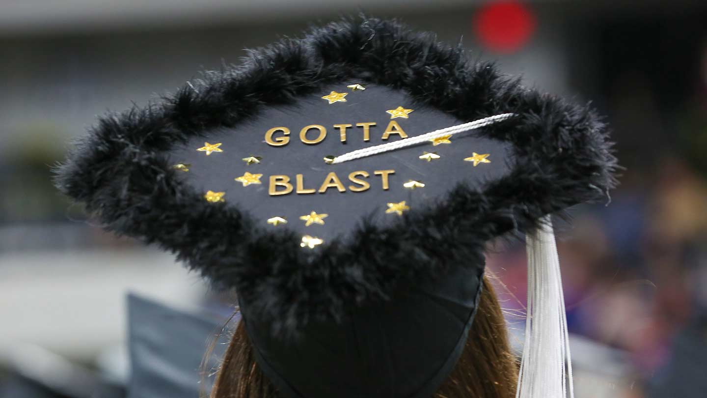 Back of gradute with graduate hat that says on top Gotta Blast