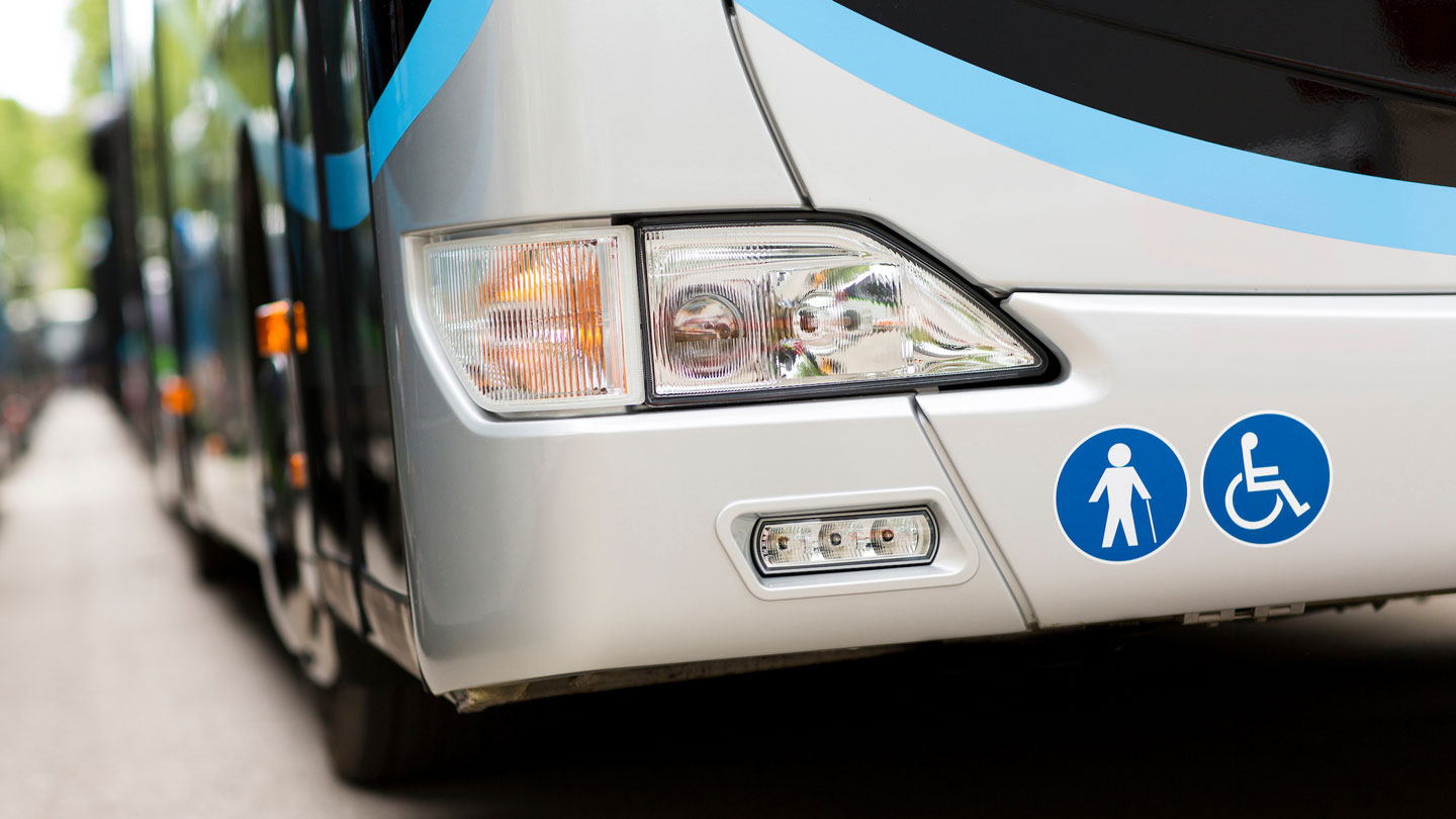 the front of a city bus with a wheelchair icon for accessibility on the bumper