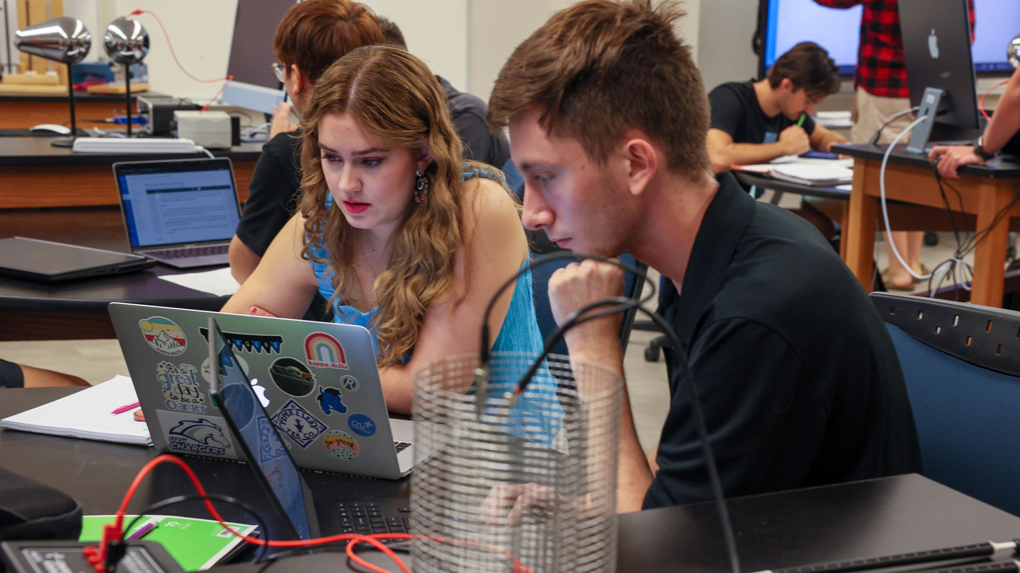 Two students work together on a lab closely