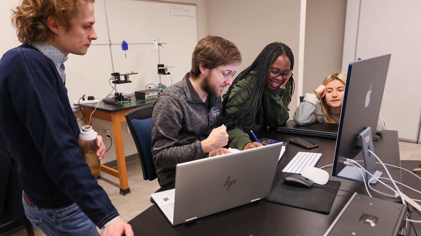 Student joyfully work on a group project together