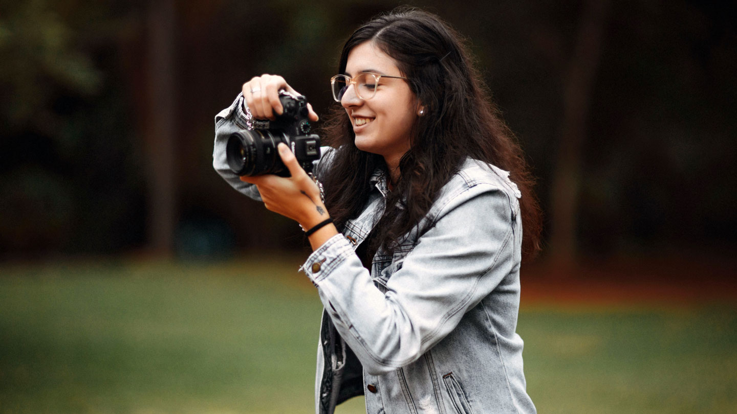 A student happily takes photos on campus