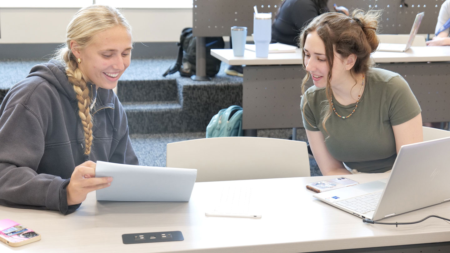 Two female students compare their work