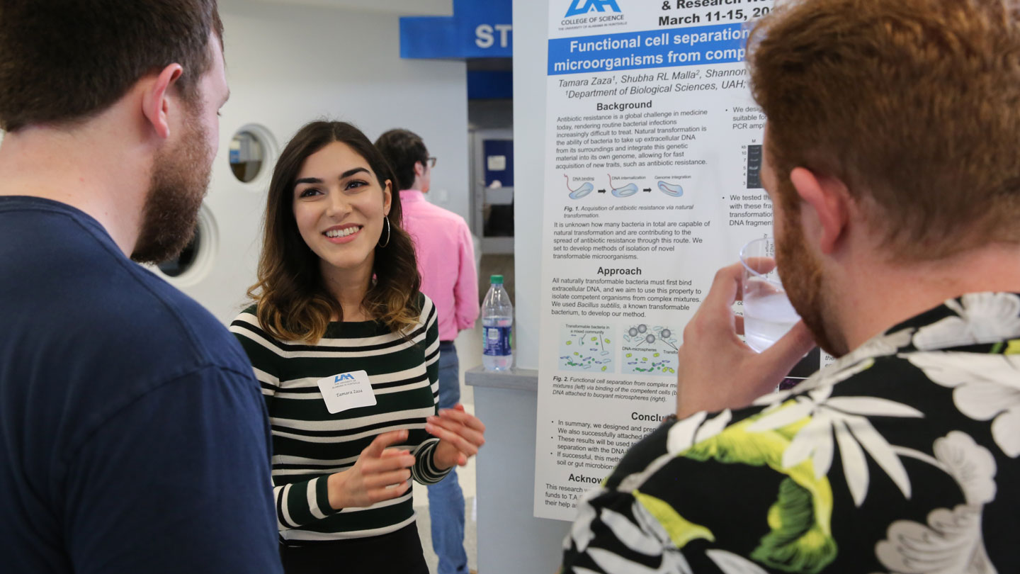 A biology student presents her microbiology presentation proudly