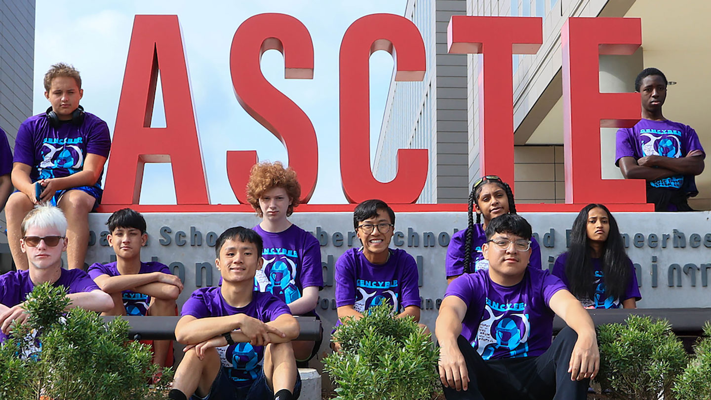 Several students pose in front of the ASCTE sign
