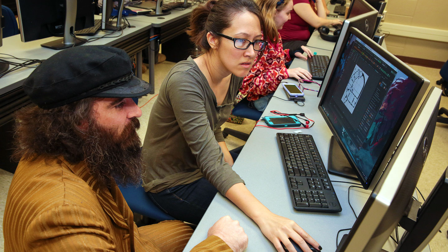 Two students help each other run computer graphics