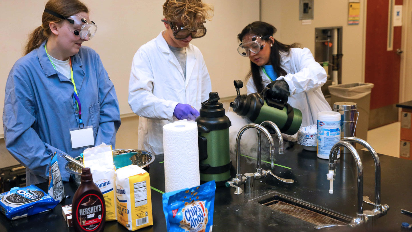 student poor liquid nitrogen on to testing materials excitedly