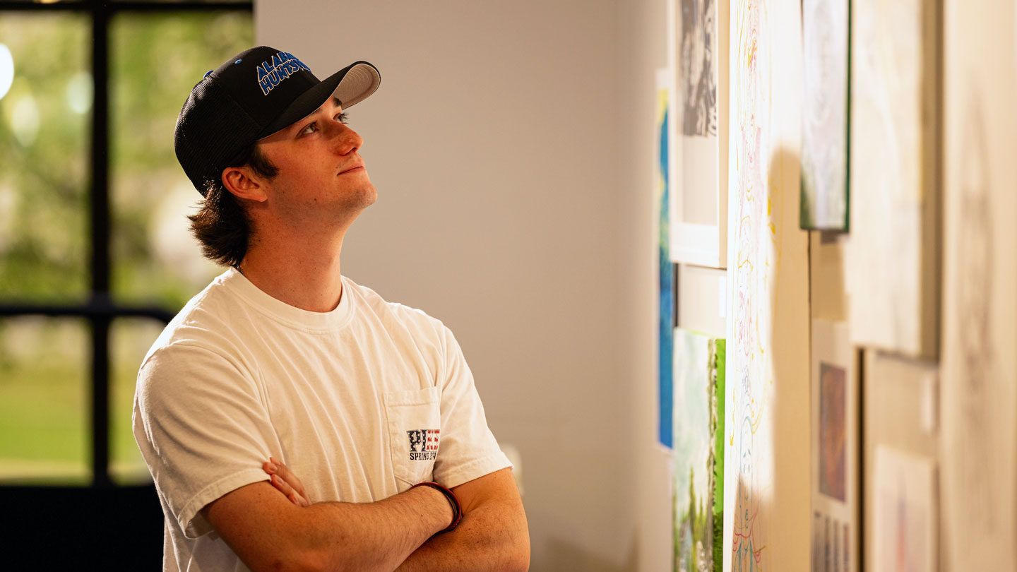 A student analyzes a wall of art