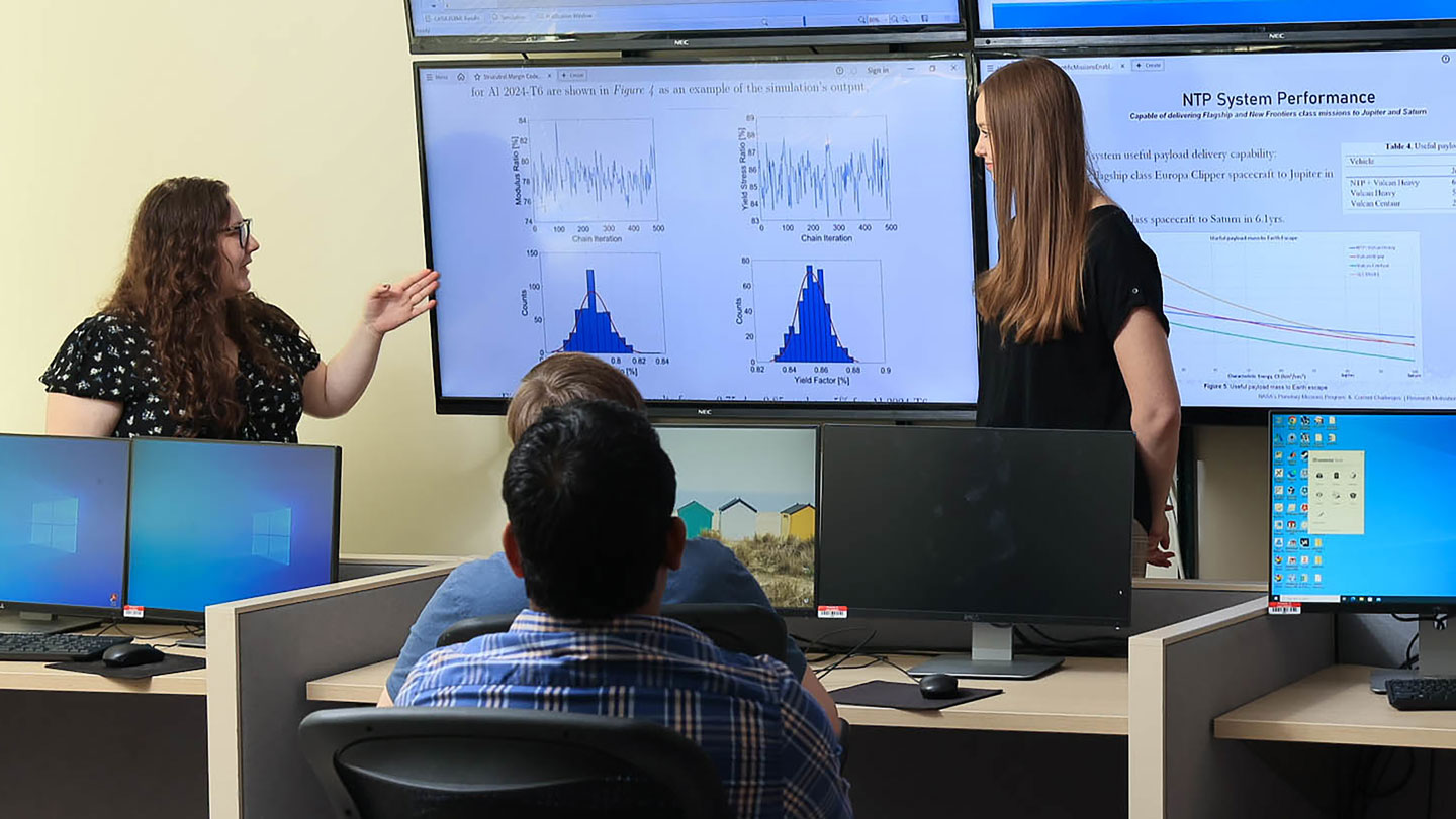 Two women give a presentation on NTP system performance data