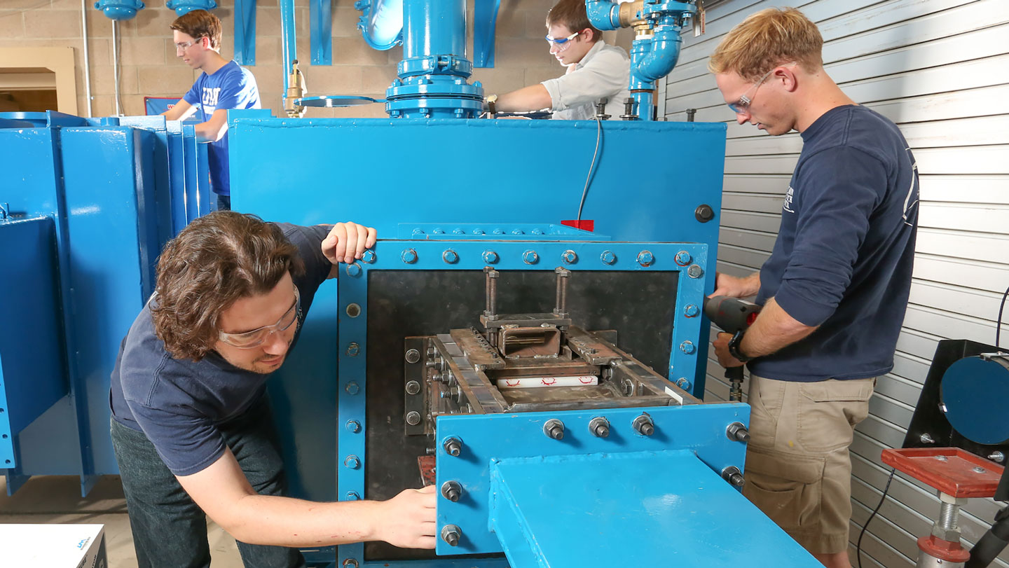 Students make adjustments to a wind tunnel