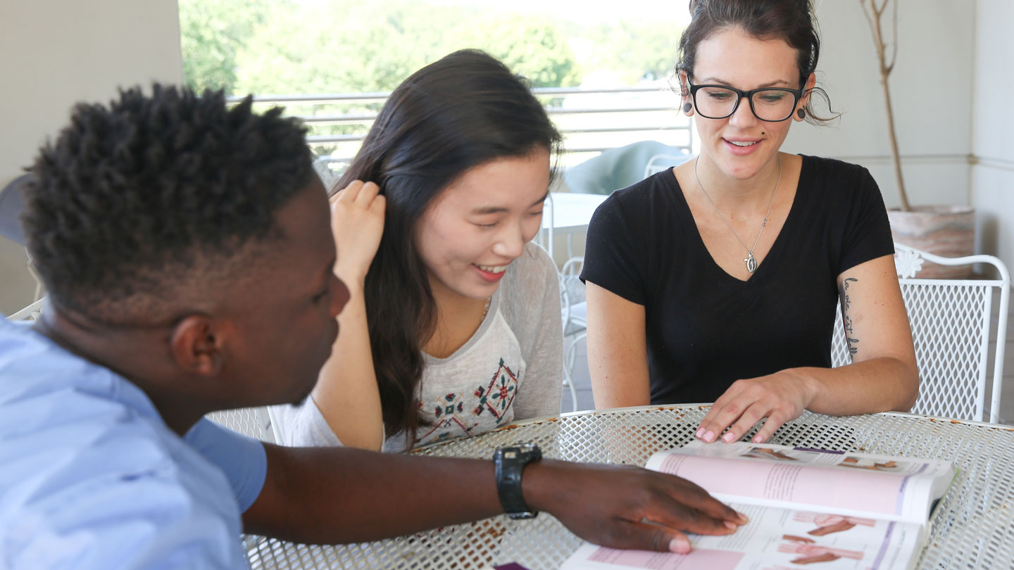 A tutor and a group of diverse students practice speaking French