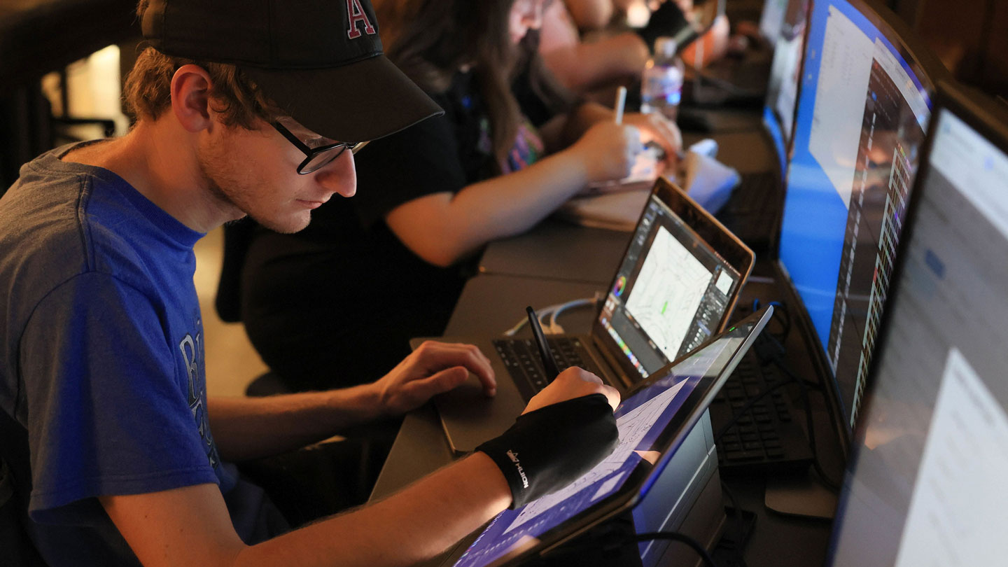 A student uses a drawing pad and laptop to make digital art