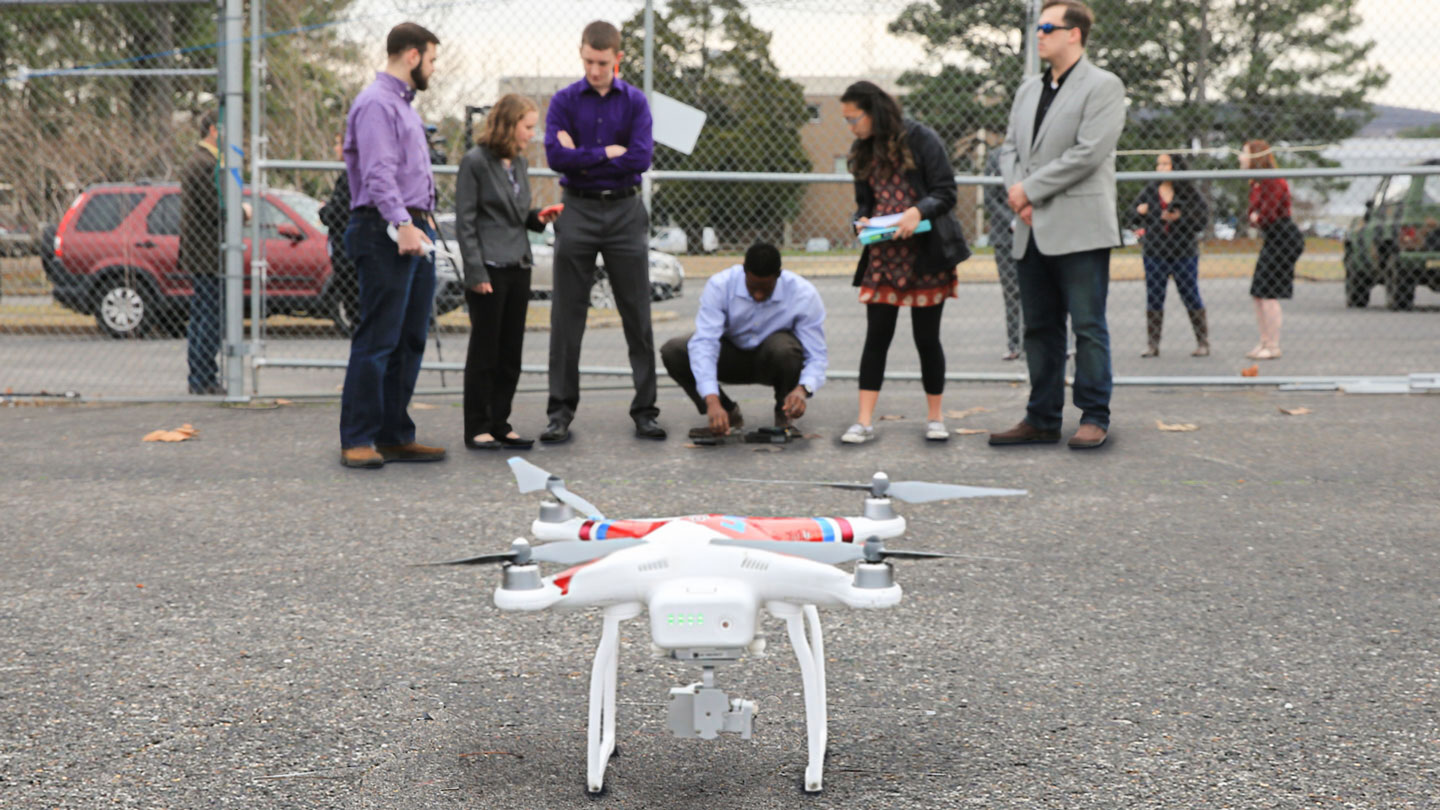 Students pilot a drone in a parking lot