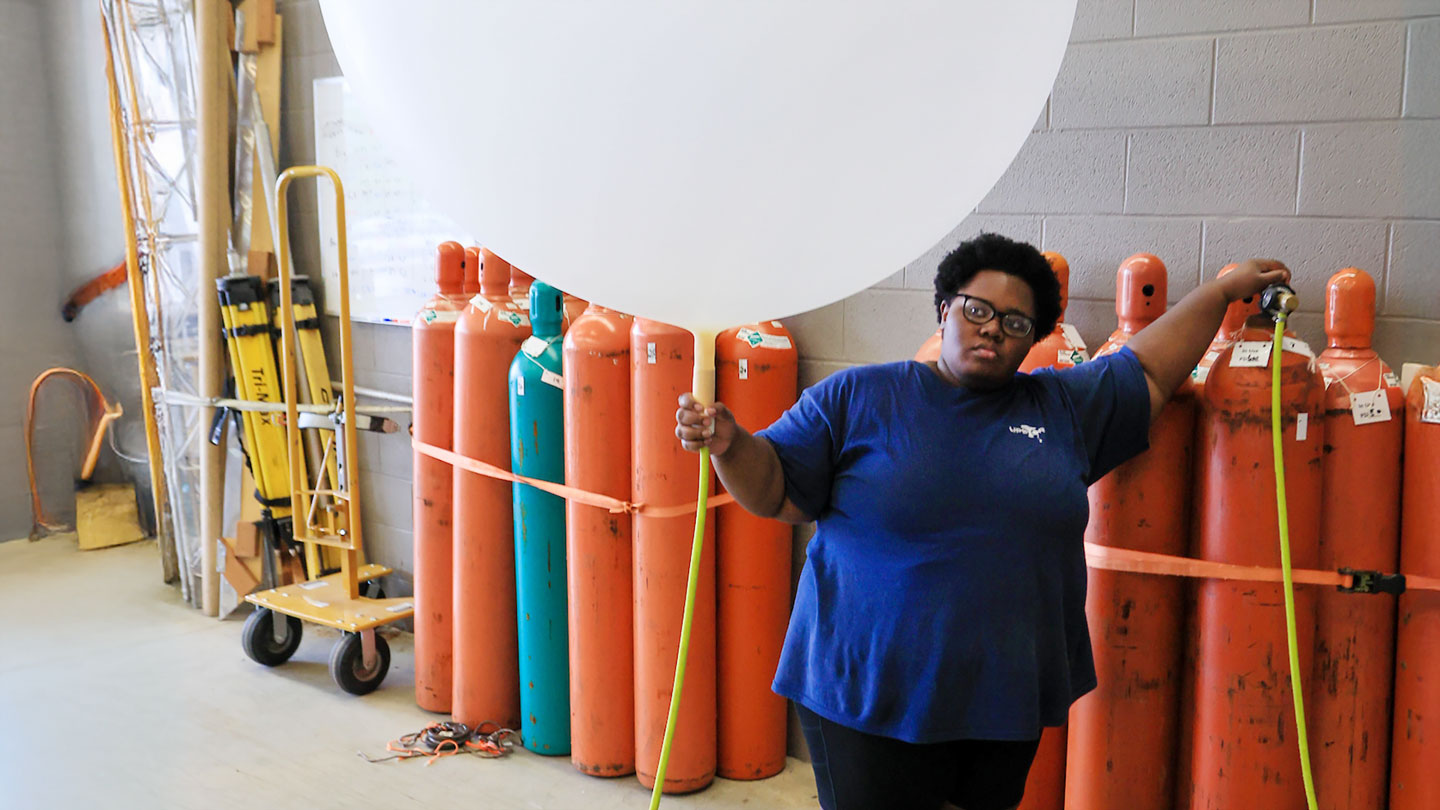 A student inflates a weather ballon