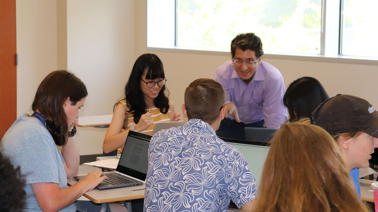 A small group of students work together one a discussion