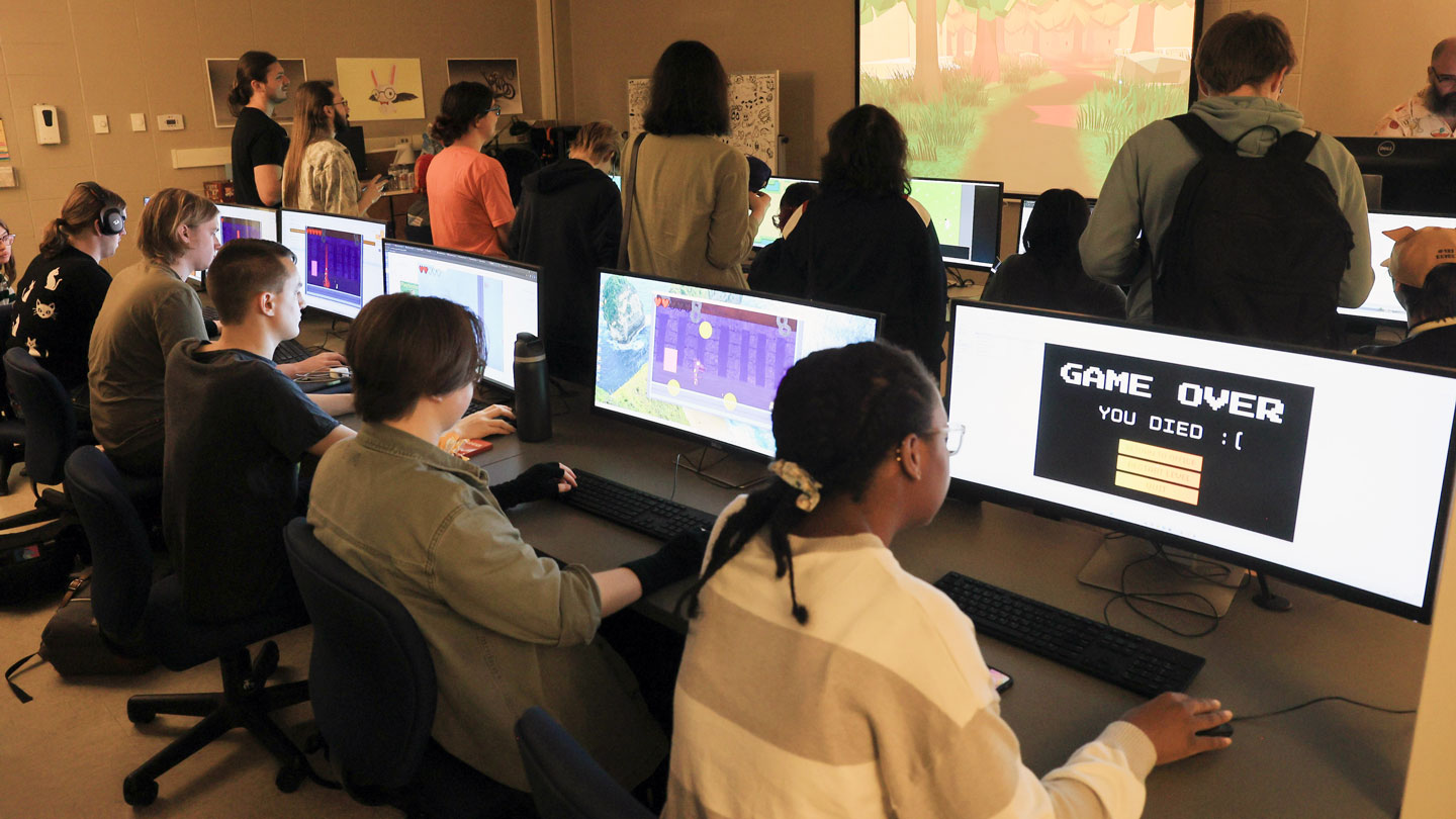 A computer lab classroom with students working on game design projects