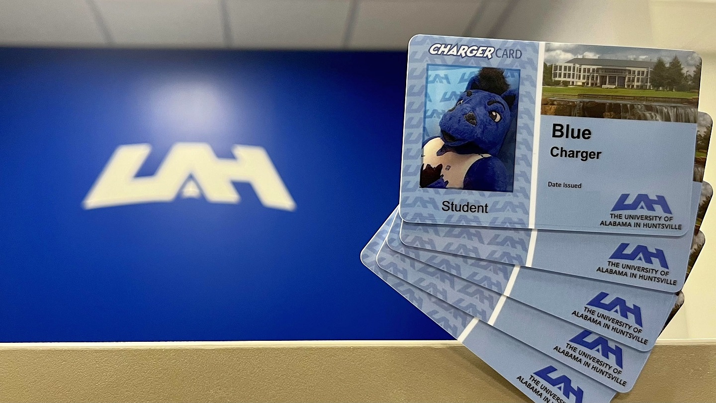 A stack of Charger Cards with the UAH logo in the background.