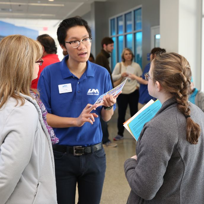 a university representative speaks with two prospective students