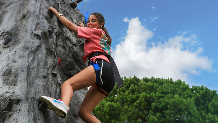 A U A H student climbs an artificial rock tower at the 2025 Rock the Rec event.