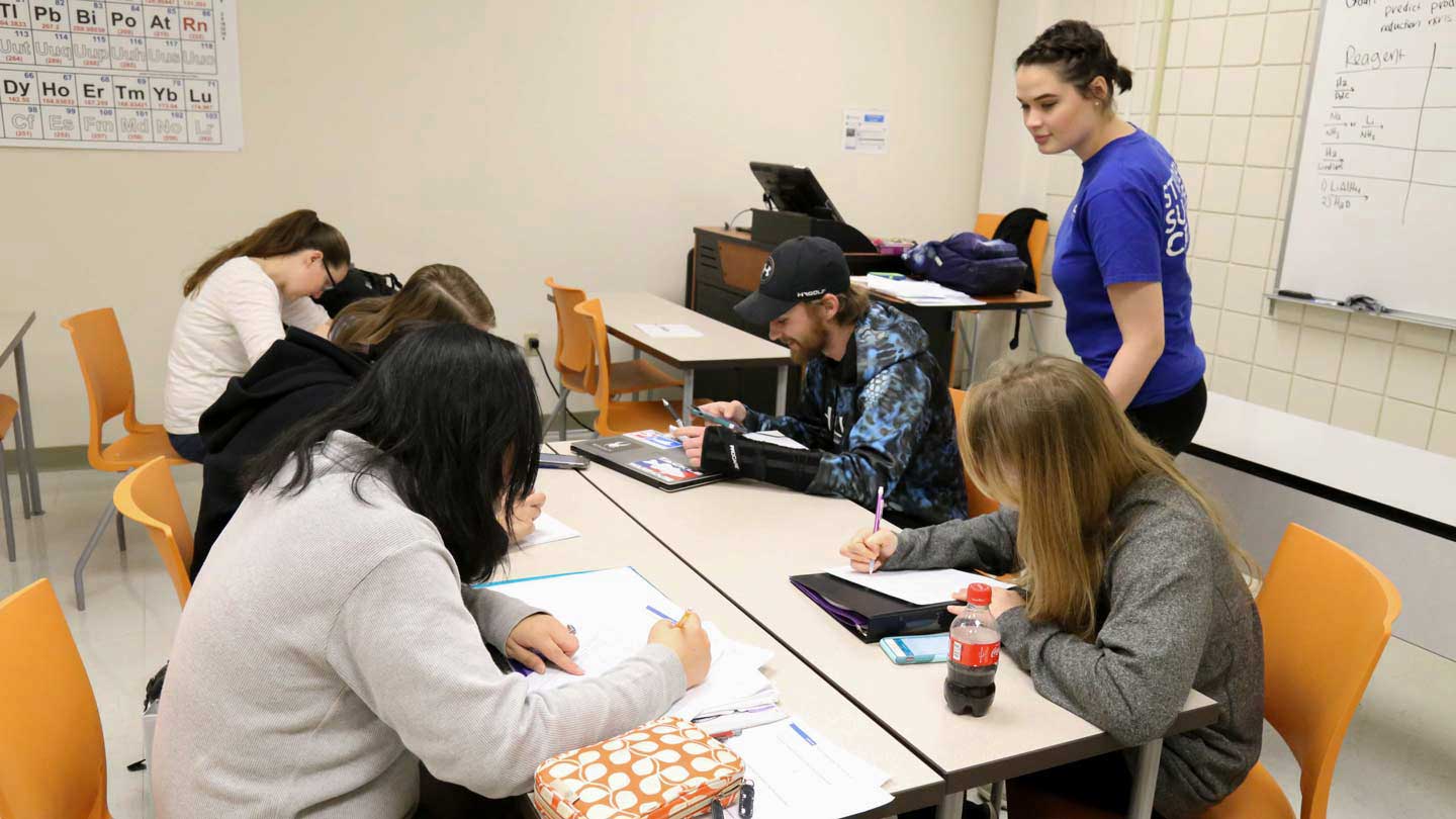 Students being tutored in a class setting.