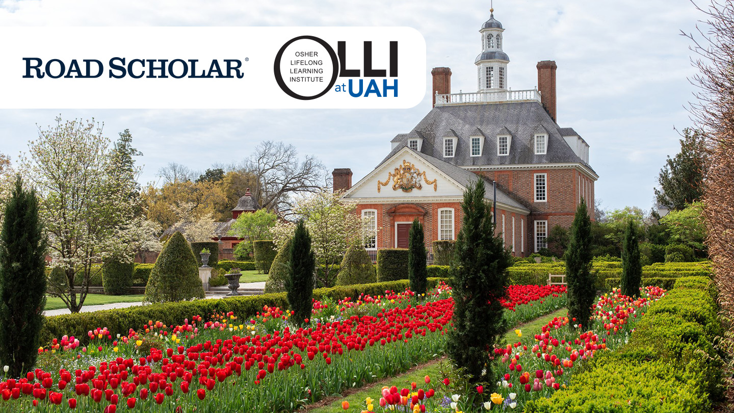 Colonial Williamsburg, a large brick colonial era house with rows of red flowers and shrubbery covering the front of the estate