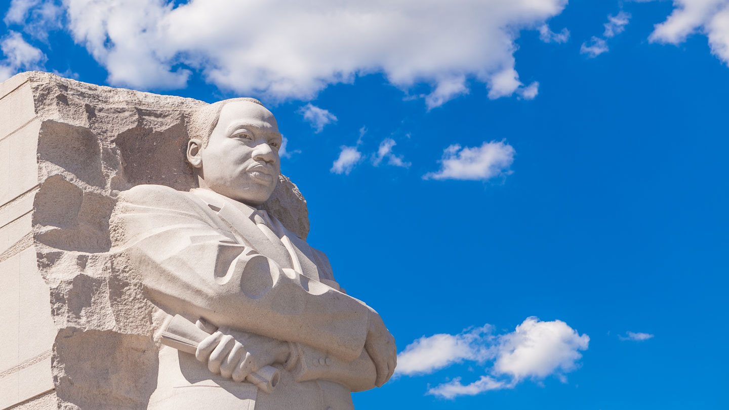 Stone sculpture of Doctor Martin Luther King, Junior in Washington D C with a clear clue sky in the background.