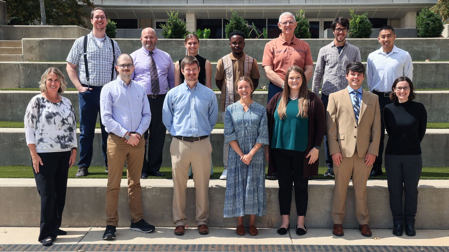 New UAH faculty members pose on a sunny terrace outside the Shelby Center for Science and Technology.