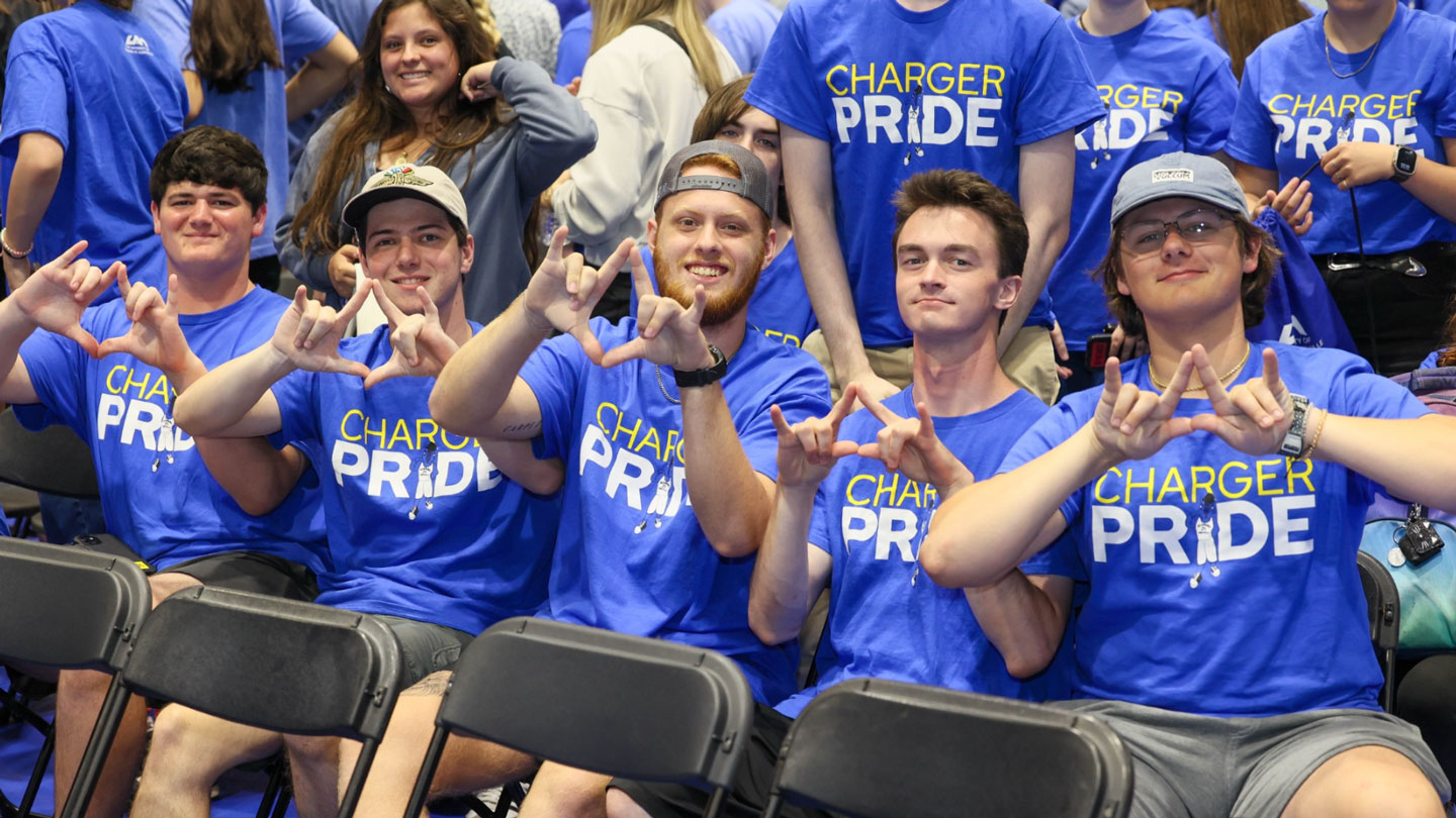 Students proudly mimic the UAH logo with hand gestures at new student orientation.