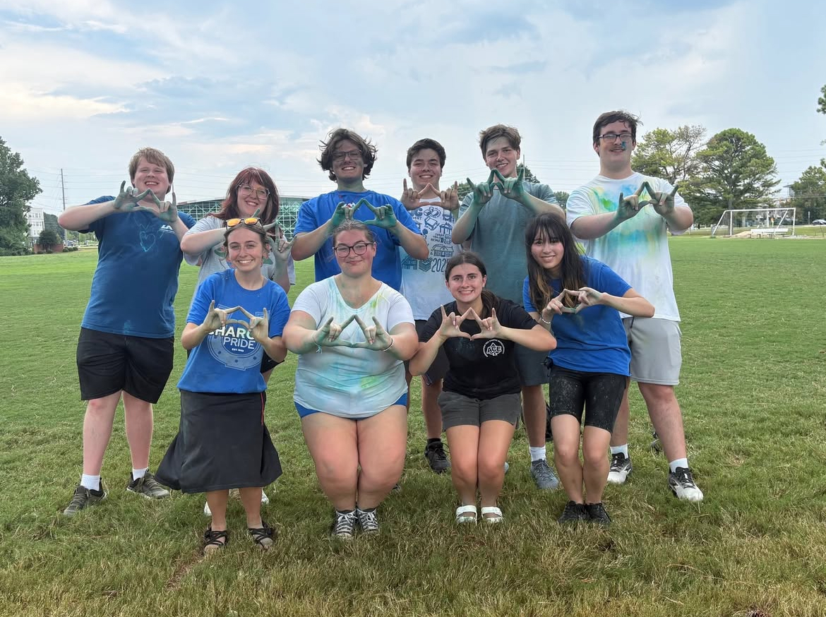 The Emerging Leaders officer team smiling at camera while showing the UAH hand sign at the Color Wars competition.