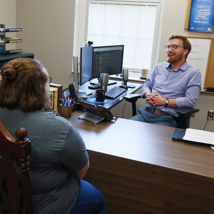 A student meets with her smiling academic advisor