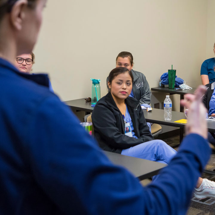 Nurse practitioner students listen carefully during a lecture.