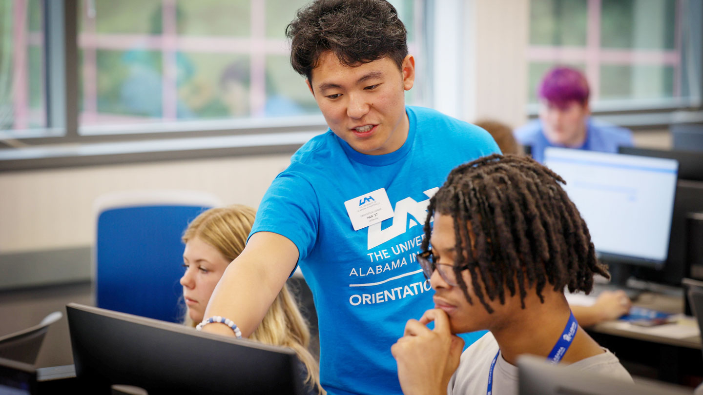 a U A H orientation leader helps a student complete registration forms
