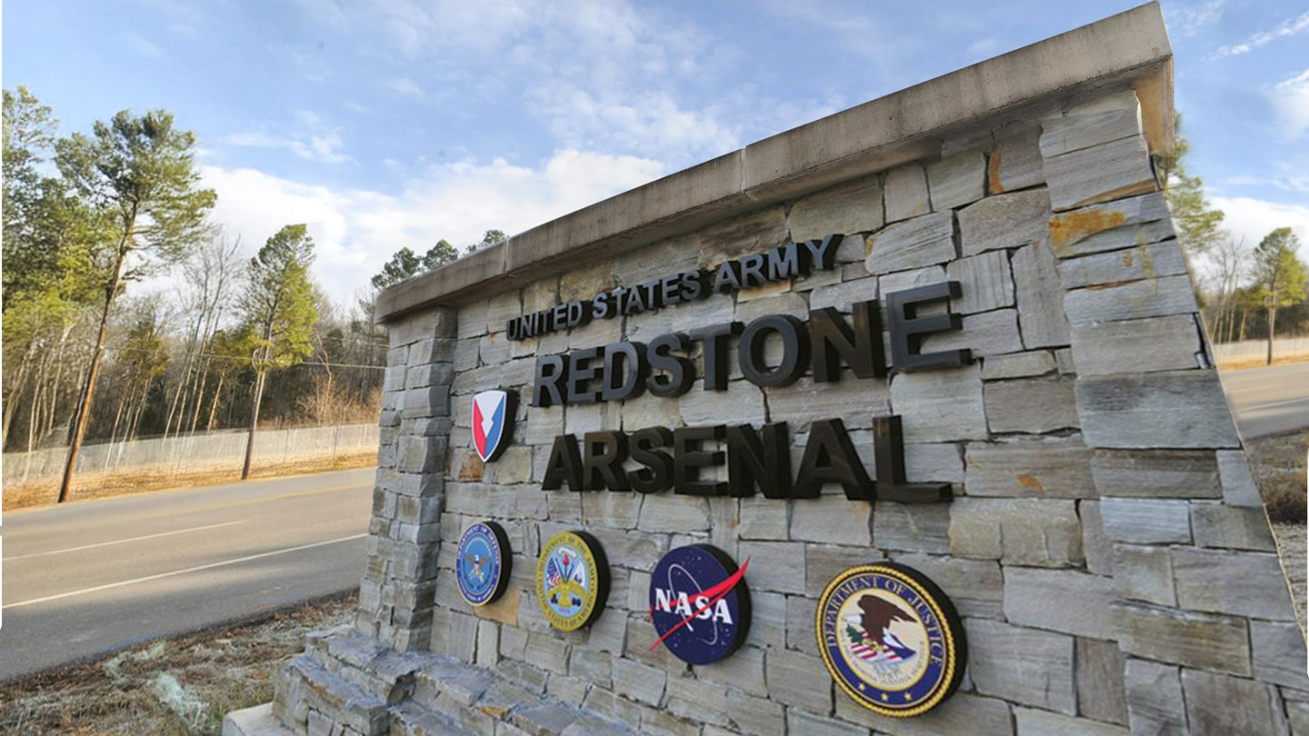 The entranceway sign at the main gate of the U.S. Redstone Arsenal displayed with emblems of the U.S. Army, NASA, and the U.S. Department of Justice