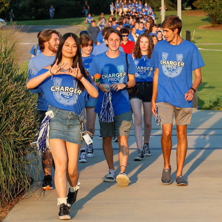 A group of excited first-year UAH students walk to an orientation event.