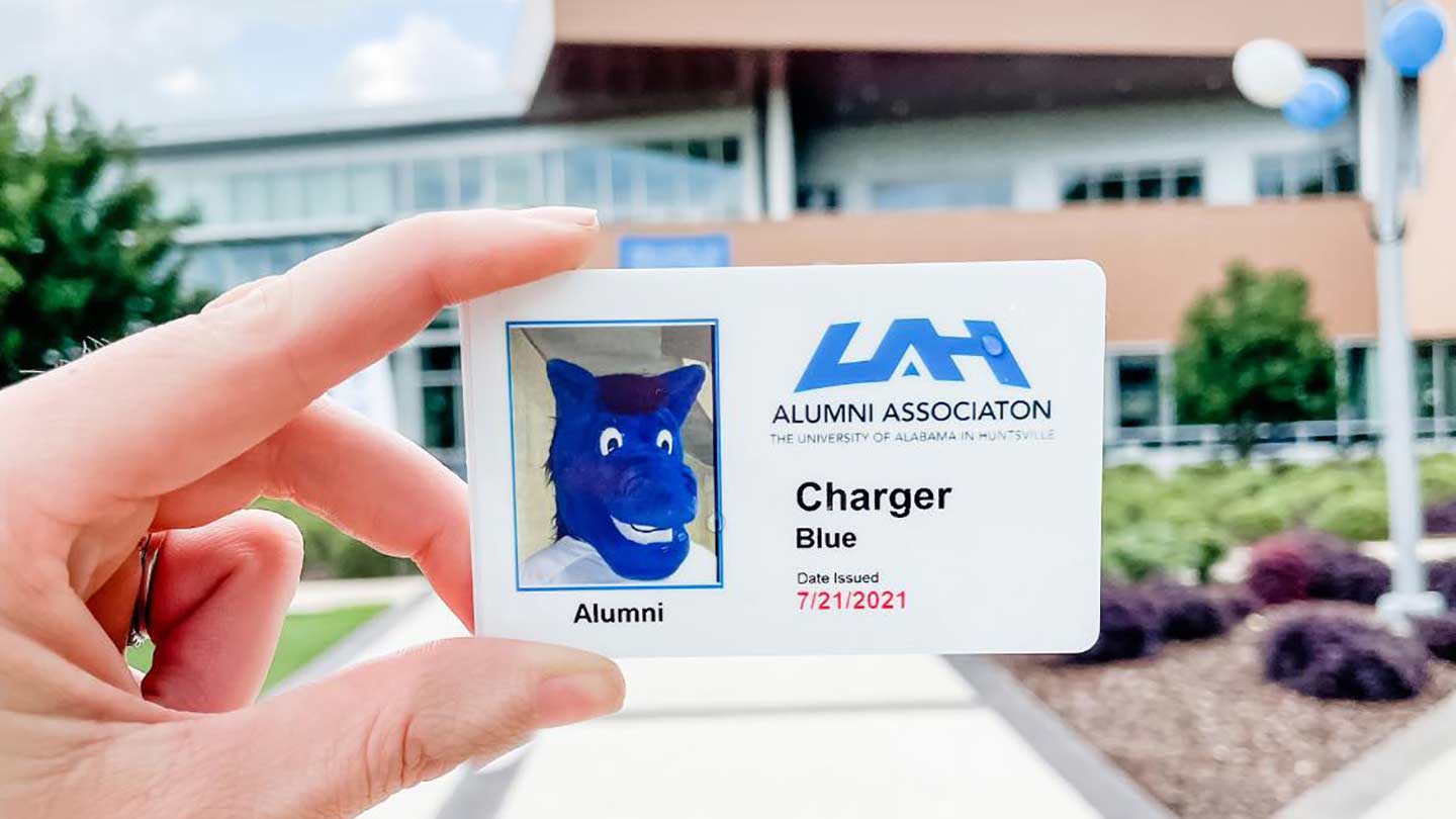 Hand holding a UAH Alumni card.