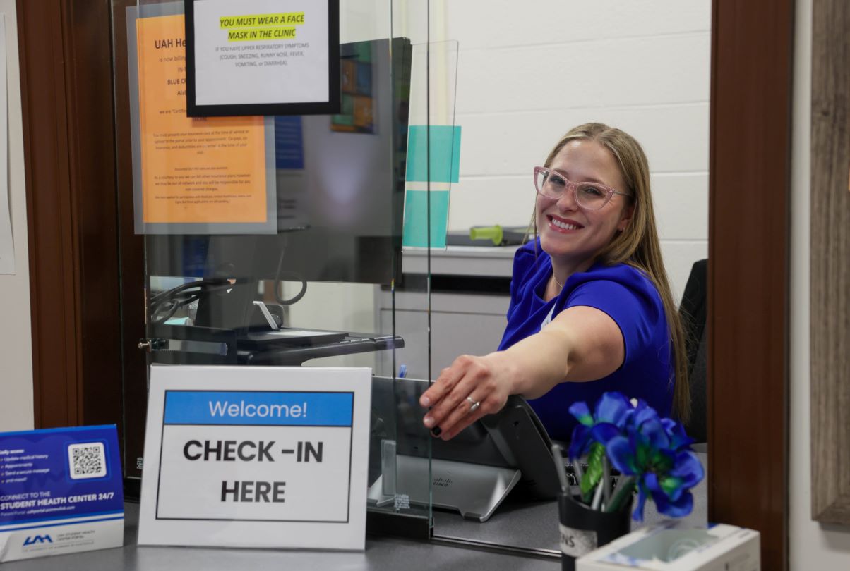 A woman sits in front of her computer at the Student Health Clinic